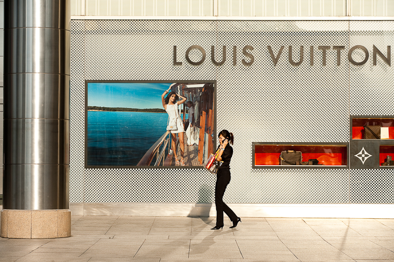 Along Ethnic Lines - An ethnic Malay woman walks in front of a Louis Vuitton store. - Kuala ...
