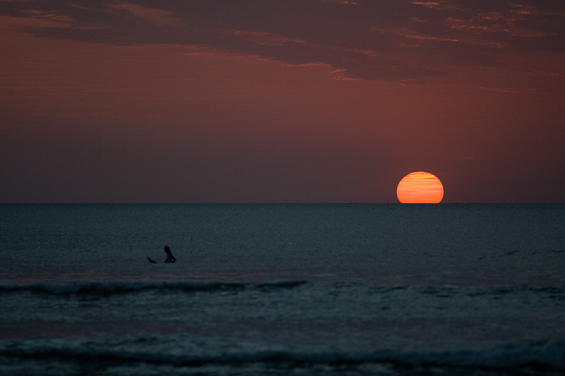 Surfer Waiting Wave Sun Dips Ocean - Kuta, Bali, Indonesia - Daily Travel Photos