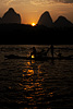 Sunrise (Karsts IV) Photo: A tourist rides on a traditional flat bamboo boat with karsts as a backdrop.