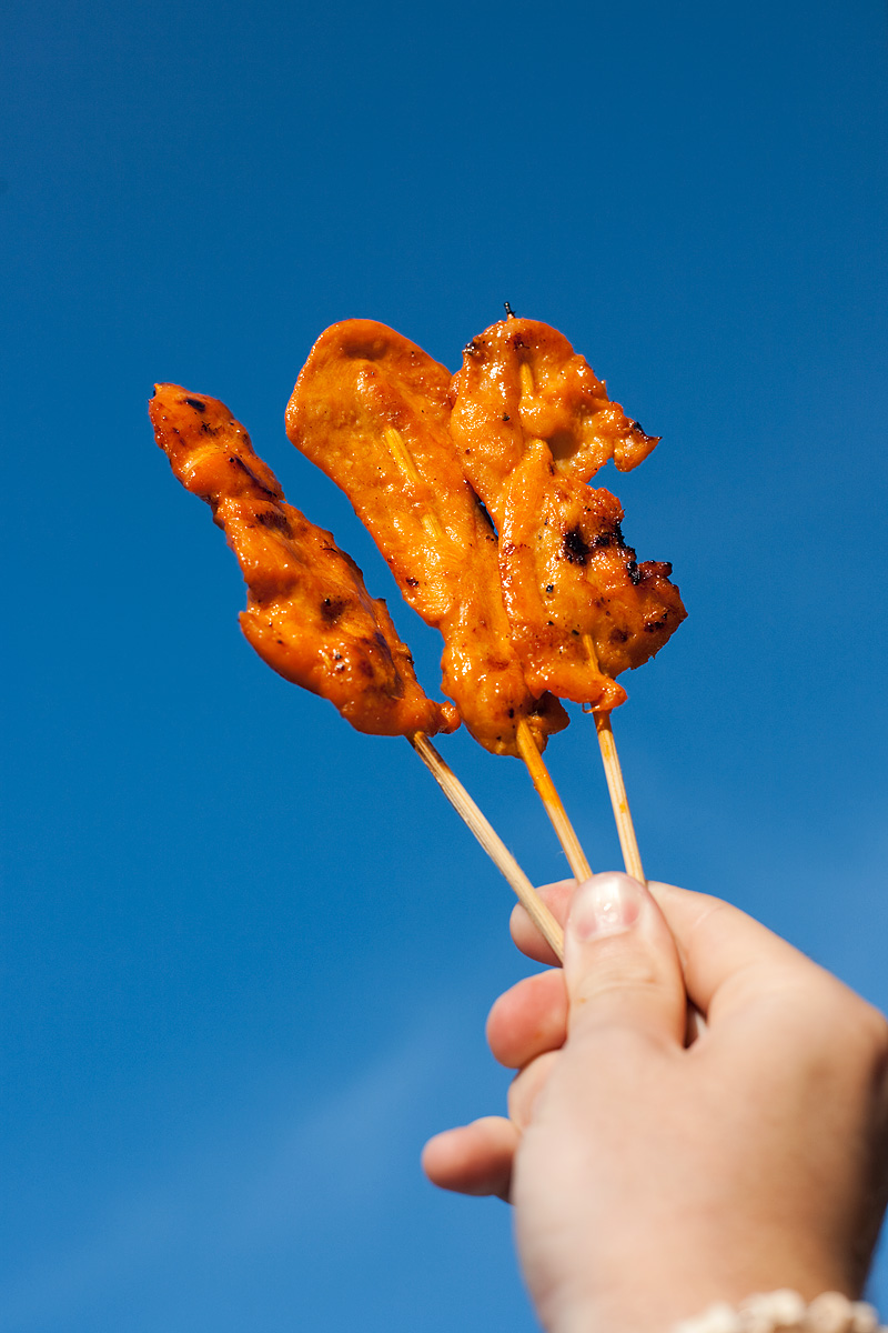 Chicken on a stick set against a blue sky. - Ko Lipe, Thailand - Daily Travel Photos