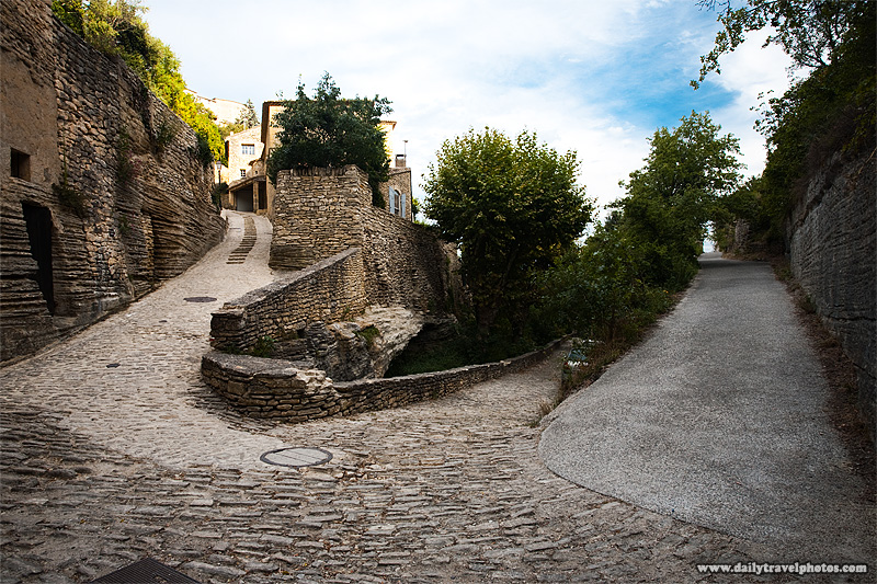Three-way stone hairpin turn street in a picturesque Provencal village - Gordes, Provence, France - Daily Travel Photos
