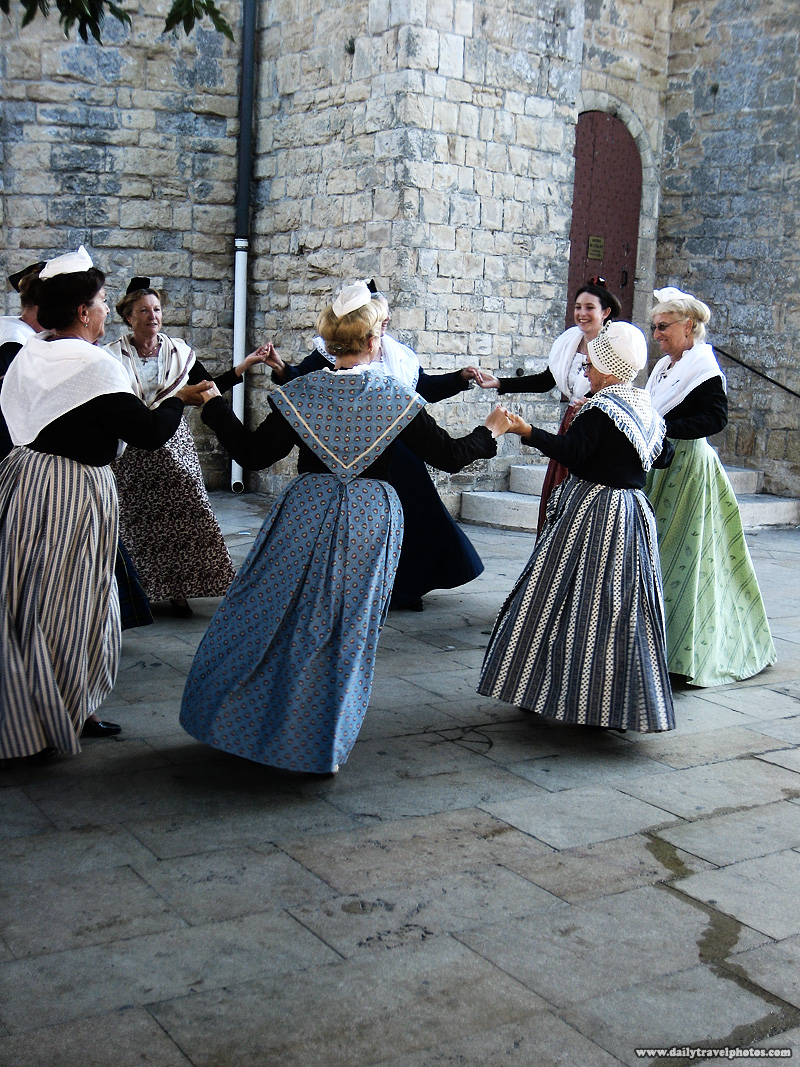 Traditionally dressed women in period costume perform a dance at the church square - Saintes Maries de La Mer, Provence, France - Daily Travel Photos