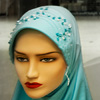 Regional Headline Photo: A Muslim shopkeep poses among her headscarves.