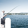 photo: Flush Fisherman - A Swiss man fishes from a boat dock into Lake Geneva.