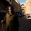 photo: Kind Caned Character - A Egyptian man stands with a cane in front of the Bab Zuweila gateway.